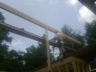 Carpenter setting a ridge beam over a new addition frame — Ice Dam Removal by Roofing Brothers in Arco