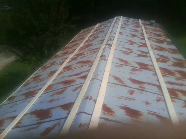 Rusted metal roof panels with new wood purlins before replacement — Storm Damage Roof Repair in Arco by Roofing Brothers