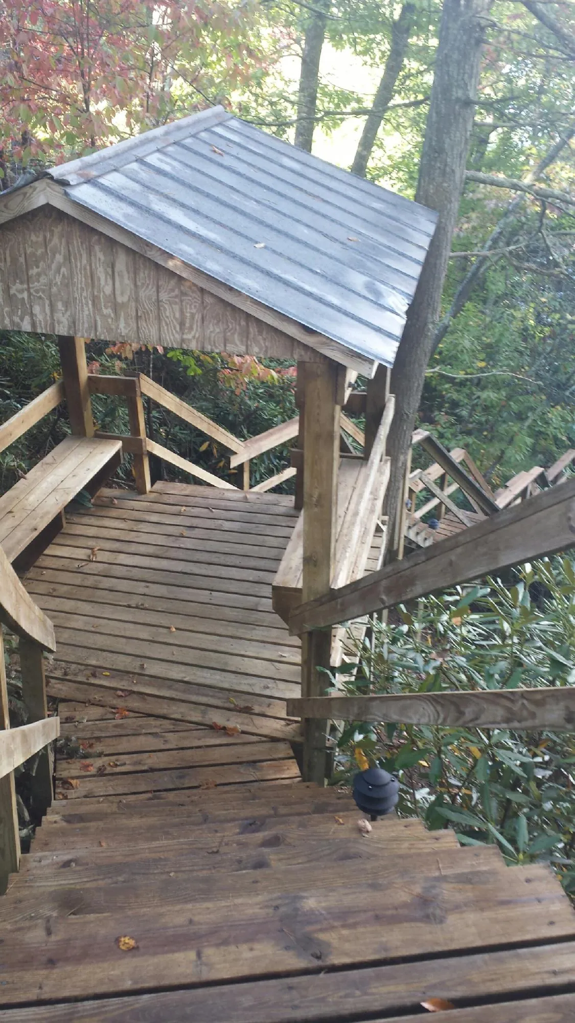 Metal roofed shelter over wooden steps on a wooded walkway — Skylight Repair & Installation work by our crew in Arco