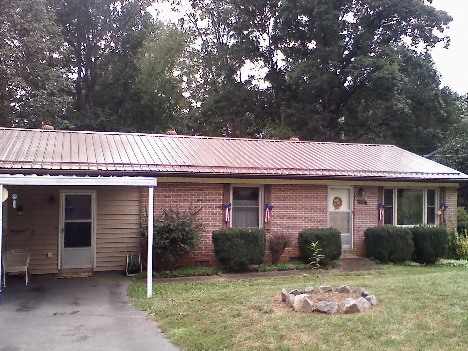 Bronze metal roof and carport on a brick ranch home — Roof Repair work by our crew in Arco